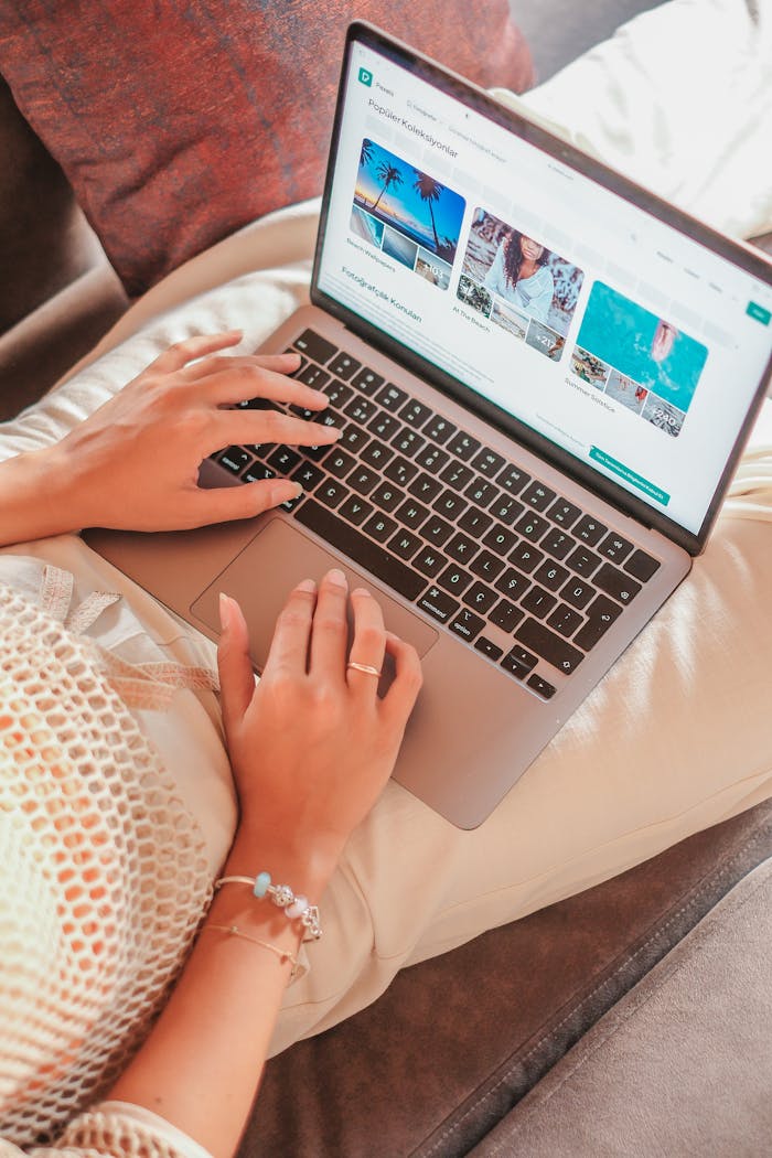 A woman comfortably working on a laptop from home, showcasing remote work lifestyle.